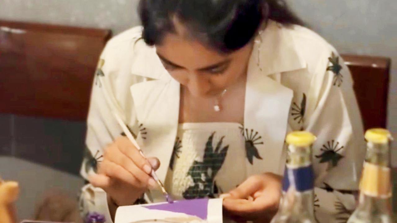 An attendee paints discarded cardboard