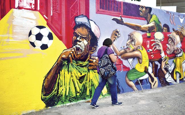 A woman walks in front of a mural painting in Rio de Janeiro. Pics/AFP