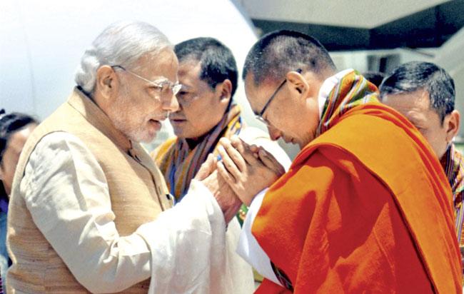 Prime Minister Narendra Modi is received by his Bhutanese counterpart Tshering Tobgay, at the Paro International Airport in Bhutan on Sunday. This is Modi’s first foreign visit as PM. Pic/PTI