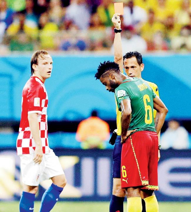 Referee Pedro Proenca gives a red card to Cameroon