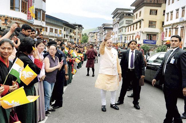 Prime Minister Narendra Modi waves at people who lined up in Thimphu to say goodbye, while he was on his way to the airport. File Pic/PTI