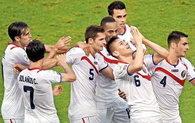 Costa Rica players celebrate their goal against Uruguay during a Group D match at the Castelao Stadium in Fortaleza recently. Pic/AFP