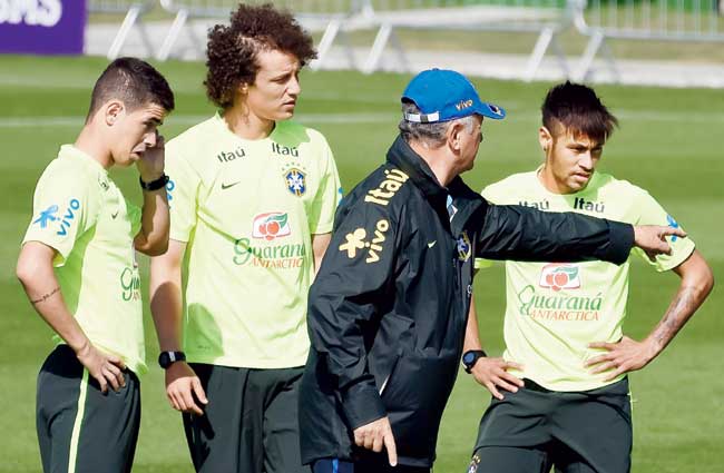 Coach Luiz Felipe Scolari gives instructions to Neymar (right), David Luiz and Oscar (right) during a training session at their training complex yesterday. Pic/Getty Images