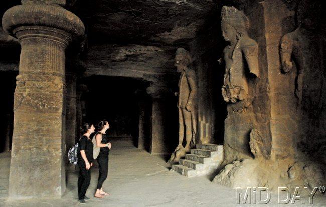 Two foreign tourists gaze at a stone edict inside the Elephanta Caves. PIC/shadab khan