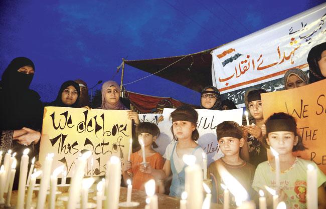 Pakistani supporters of Tahir-ul-Qadri hold a candlelight vigil in the memory of the victims of the clashes with police, in Islamabad on June 18. At least eight people were killed on June 17, when Pakistani police clashed with followers of the influential preacher in Lahore. Pic/AFP