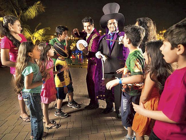 Ganesh Darvesh with his fellow magician showing kids some tricks