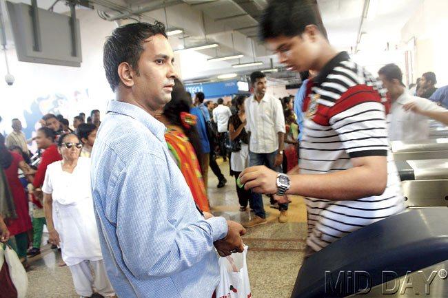 An official collects tokens in a plastic packet at Ghatkopar station, to hasten the exit of people, who would otherwise have to file out in a single row after dropping their tokens into receptacles to open the exit barriers. Pics/Emmanual Karbhari