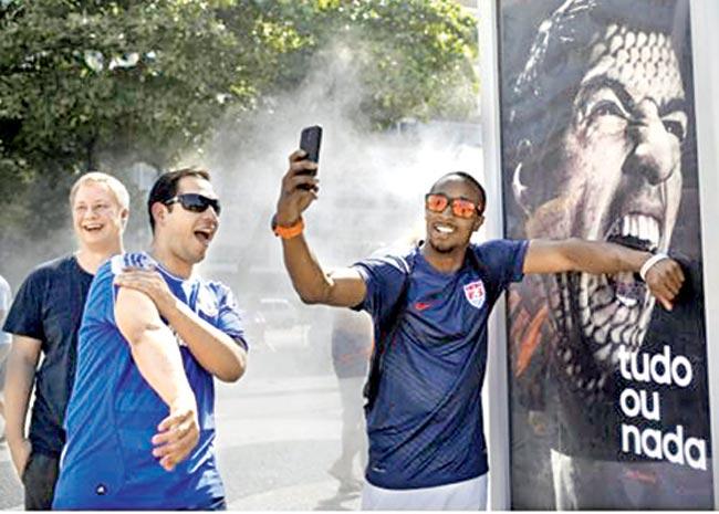 Fans pose with a poster of Luis Suarez depicting him as a shark from Jaws.