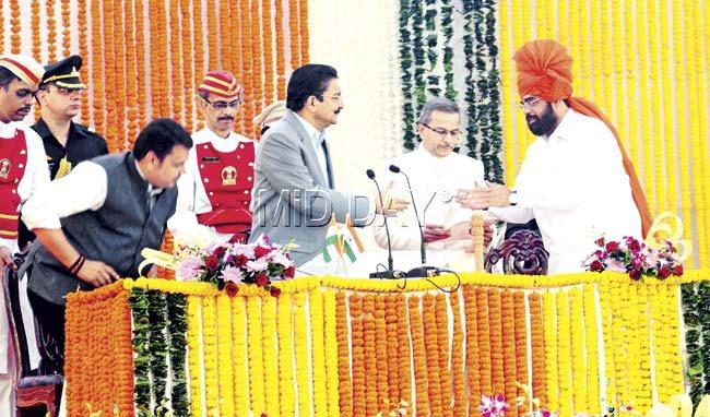 Shinde being sworn in as a cabinet minister yesterday. Waikar was sworn in as a minister of state. Pic/Sayed Sameer Abedi