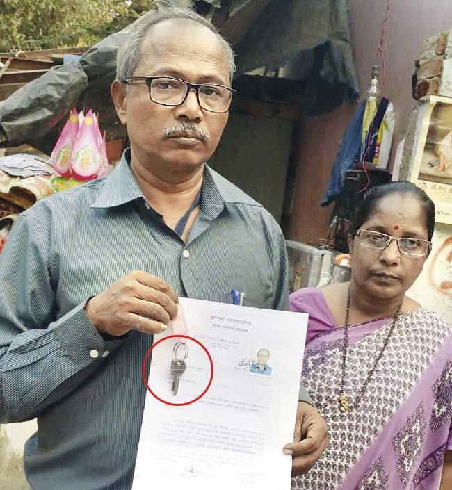 Vidyadhar Jadhav and his wife with the key (circled) and possession letter of their new flat