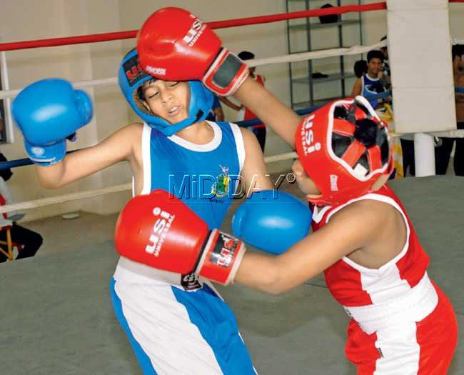Shahnawaz Ansari (in red) lands a punch on Taher Motiwala during the U-12 MSSA inter-school boxing championships at the District Sports Office complex in Dharavi yesterday. Pic/Sameer Markande