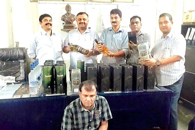 in police net: Deepak Arunkumar Shah (sitting) was caught with  37 bottles of foreign liquor on  September 27 in Worli