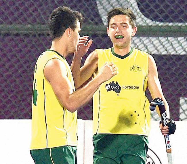 Flynn Ogilvie (right) celebrates an Australia goal with a teammate at Bhubaneswar