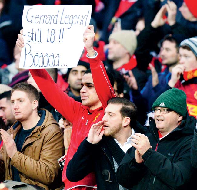 Manchester United fans hold up a banner taunting Liverpool veteran Steven Gerrard yesterday 