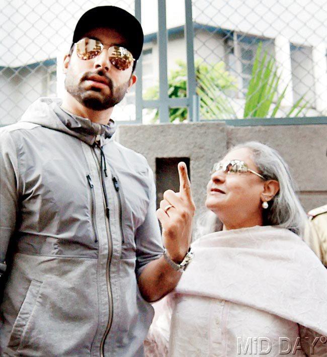 Abhishek Bachchan sticks up his inked finger as mom, Jaya Bachchan, takes a close look at it 