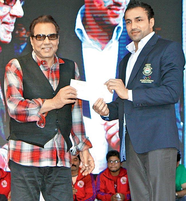Kabaddi champion, Rakesh Kumar (right) receives a cheque from Dharmendra 