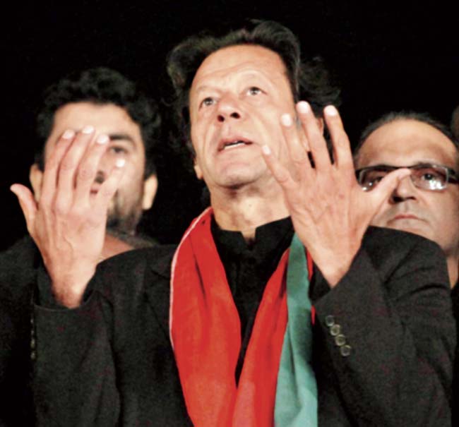 The buck stops here: Pakistani cricketer-turned-politician Imran Khan, leader of the Pakistan Tehreek-e-Insaf party, prays for the victims killed in the attack on a military-run school in Peshawar, during a sit-in protest in Islamabad, on Wednesday. Khan has decided to end his party’s sit-in protests following Tuesday’s  attack. Pic/AP/PTI