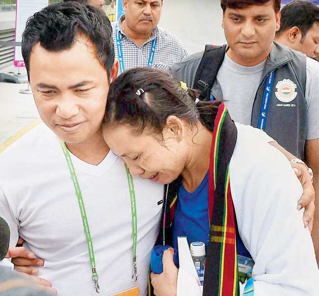 Sarita Devi is being consoled by her husband Thoiba after her semi-final loss yesterday. Pic/PTI