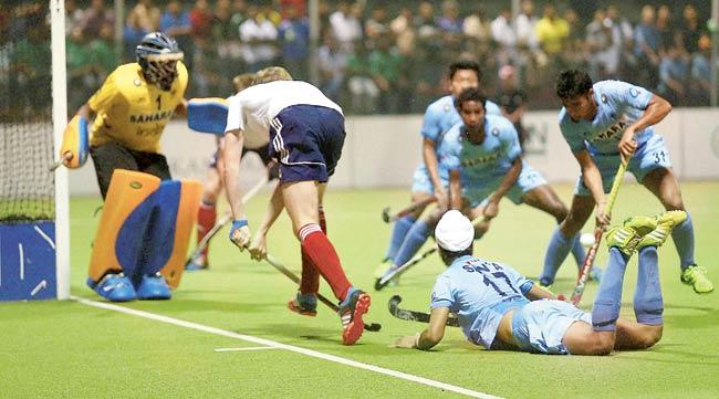A British player (in white) is thwarted by the Indian defence during the final of the Sultan of Johor Cup in Malaysia yesterday. Pic/PTI