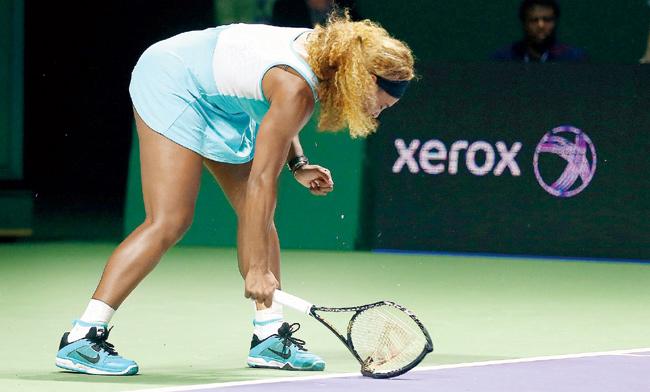 Serena Williams smashes her racket after losing a point on Saturday
