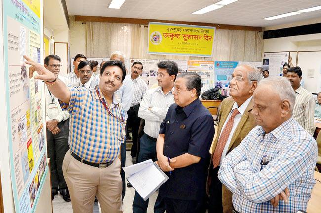 (Left to right) BMC PRO Vijay Khabale explains while Additional Municipal Commissioner Rajiv Jalota looks on as former civic chief Johnny Joseph (in blue), and bureaucrats Dinesh Afzalpulkar (in suit) and D M Sukthankar (extreme right) judge ‘Good Governance’ posters at the BMC office on Friday.