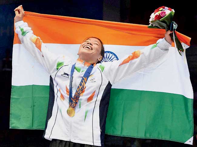 MC Mary Kom holds aloft the Indian tri-colour after her victory over Zhaina Shekerbekova of Kazakhstan in the gold medal clash of the 51kg category yesterday. Pic/PTI