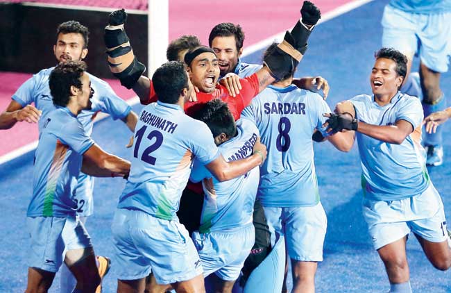 India players hug goalkeeper PR Sreejesh (in red jersey) after his heroics in the penalty shootout against Pakistan during the men’s hockey final at Incheon