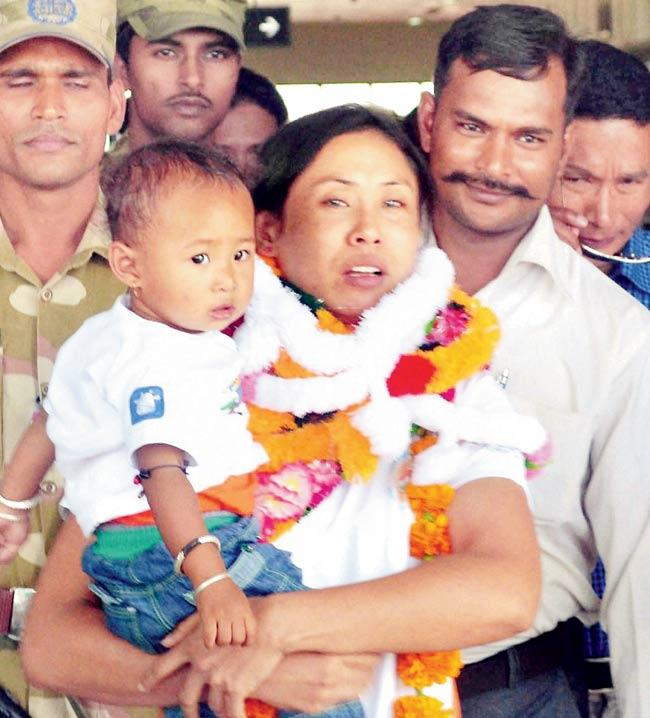 Boxer L Sarita Devi (seen with her son) arrives at the Imphal airport on Saturday after a bittersweet Asian Games in Incheon. Pic/PTI