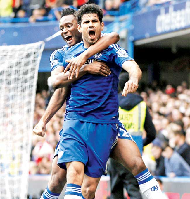 Chelsea striker Diego Costa celebrates with teammate John Obi Mikel after scoring against Arsenal in an EPL match at Stamford Bridge yesterday