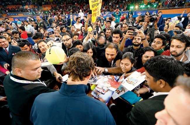Roger Federer of Indian Aces signs autographs after his victory over Singapore Slammers