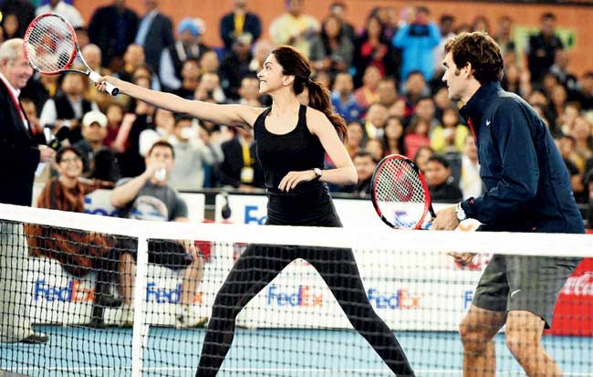 Bollywood actress Deepika Padukone returns during her mixed doubles exhibition match partnering Roger Federer at the IPTL in New Delhi yesterday