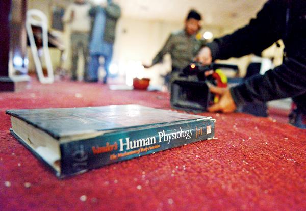 A textbook lies on a carpet at the school. The insurgents had systematically gone from room to room, shooting children during the eight-hour killing spree. Pics/afp