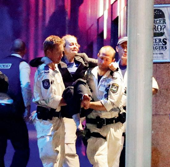 A woman carried out by police from the Lindt Cafe, Martin Place, following the hostage standoff in Sydney yesterday. 