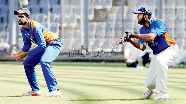 Mumbai skipper Suryakumar Yadav (left) performs a catching drill with teammate Wasim Jaffer