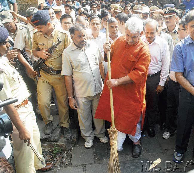 Minister of State for Railways, Manoj Sinha, makes his contribution to the ‘Swachh Bharat’ cleanliness drive by sweeping the footpath outside CST. Pics/Sayyed Sameer Abedi