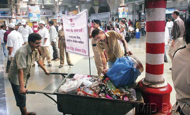 Railway workers pick up trash inside CST premises during the country’s biggest cleanliness drive launched yesterday