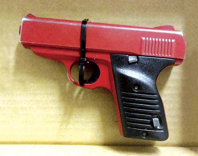 This photo, provided by the Hamilton County Sheriff in Cincinnati, shows a red-painted, .380-caliber handgun police found during the arrest of 23-year-old Orlando Lowery. Pic/APF