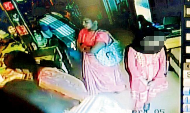 CAUGHT ON CAM: The teenage girl (face blurred as she is a minor) who robbed the jewels from the cupboard. The woman in pink sari with a bag is one of the accomplices
