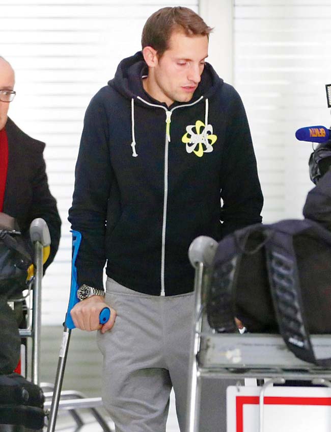 Renaud Lavillenie arrives at the Charles de Gaulle Airport on crutches yesterday. Pic/AFP