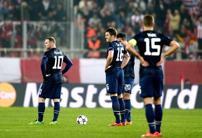 Manchester United-s British forward Wayne Rooney L and British midfielder Michael Carrick C, Dutch forward Robin van Persie 2nd R and Serbian defender Nemanja Vidic react after Olympiakos scored a second goal during the round of 16 Champions League football match Olympiakos vs Manchester United at Karaiskaki Stadium in Athens. Pics/AFP