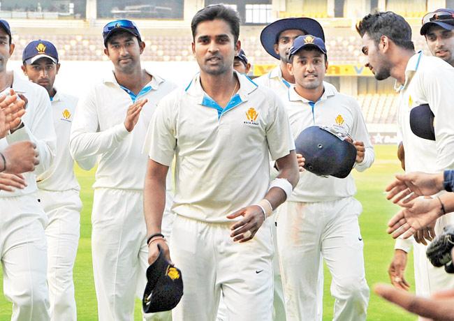 Karnataka captain R Vinay Kumar (centre) leads his team out of the ground yesterday. He took 4-84