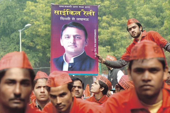 A supporter holds up a portrait of UP CM Akhilesh Yadav during a Samajwadi Party election campaign. The bicycle rally, will run for two weeks as campaigners cycle from New Delhi to Lucknow. Pic/AFP
