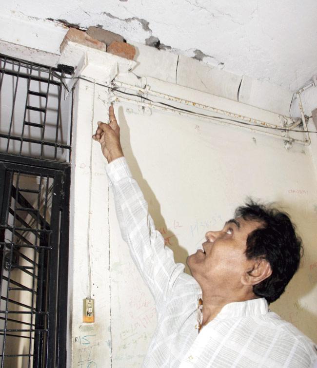 A resident points to the cracks in the building’s structure at Dadar-Matunga area