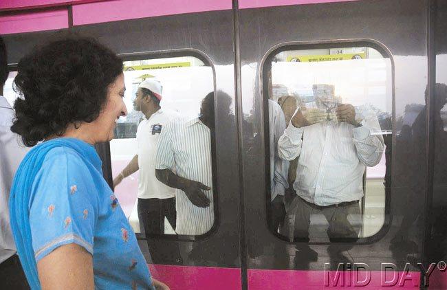 A woman obliges a monorail commuter shooting a video from inside the train