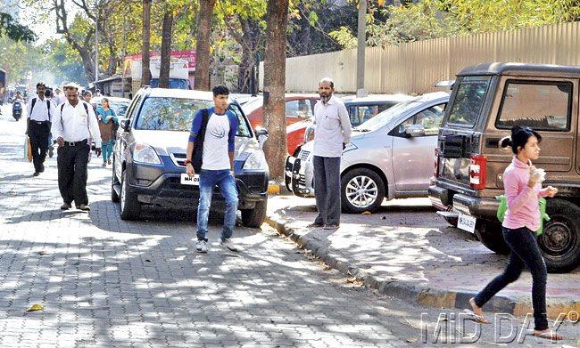 As cars take up all the space on the footpath at Dr SS Rao Road, Parel, pedestrians have no option but to walk on the busy road. Pic/Datta Kumbhar