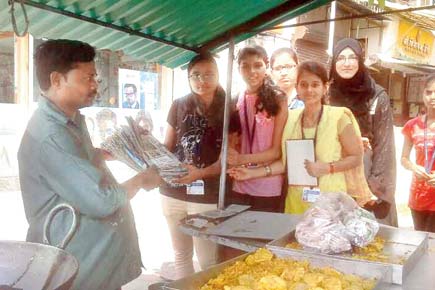 College students distribute  paper bags for greener plant