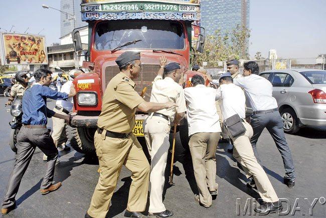 Policemen try and move a water tanker, which was halted in the middle of the road by MNS activists on Tilak Bridge in Dadar, after news broke that their leader Raj Thackeray had been detained at RCF police station. Pics/Rane Ashish