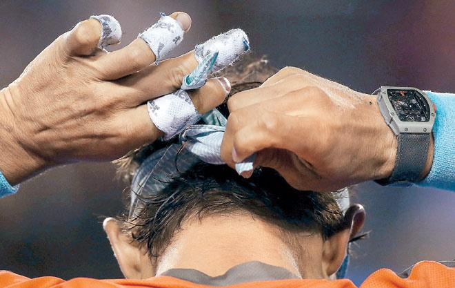 Nadal displays his taped fingers while adjusting his  headband. Pic/Getty Images