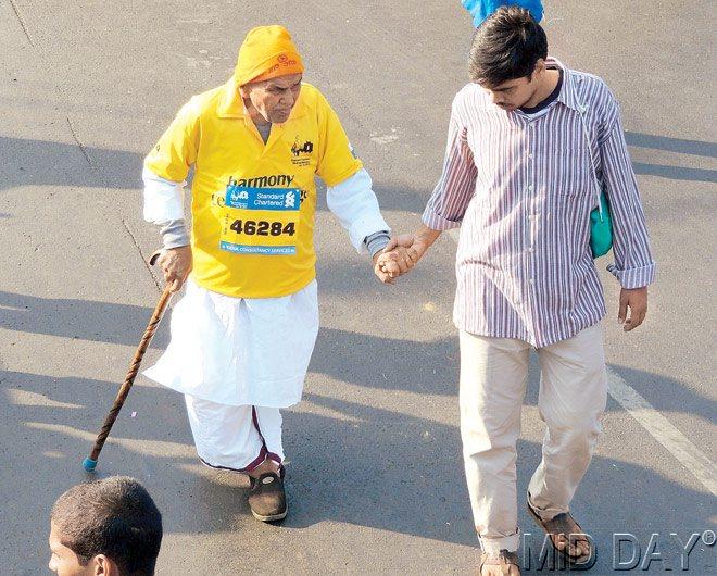 90-year-old Muralidhar crosses the finish line with his grandson Rakesh at  the Mumbai Marathon yesterday. Pic/Amit Kamath