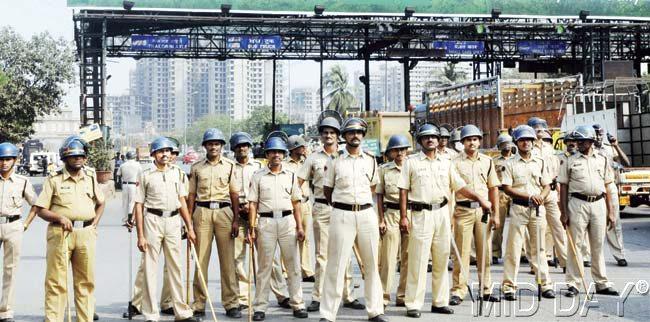Police platoon stand guard outside Dahisar toll plaza to prevent MNS workers from vandalising it. Pics/Nimesh Dave